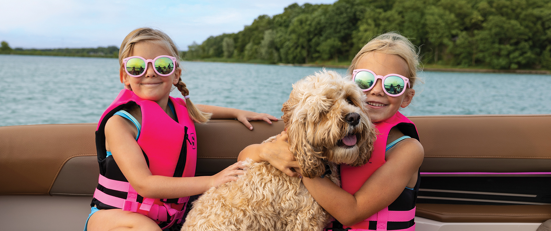 Girls on a pontoon boat with Golden Doodle on Kawagama Lake